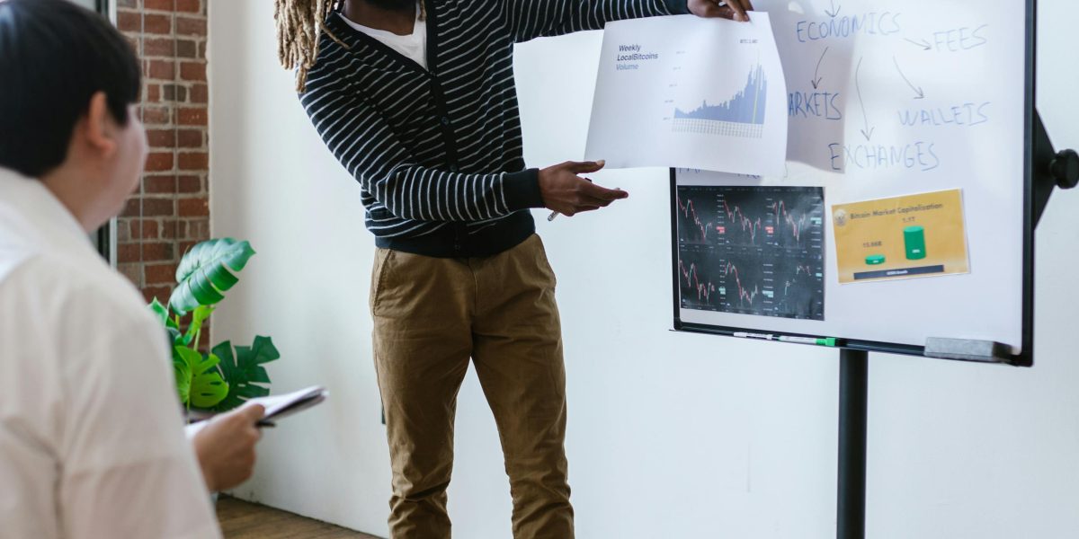A professional analyzing data and sketching ideas on a whiteboard, representing strategic property investment planning.
