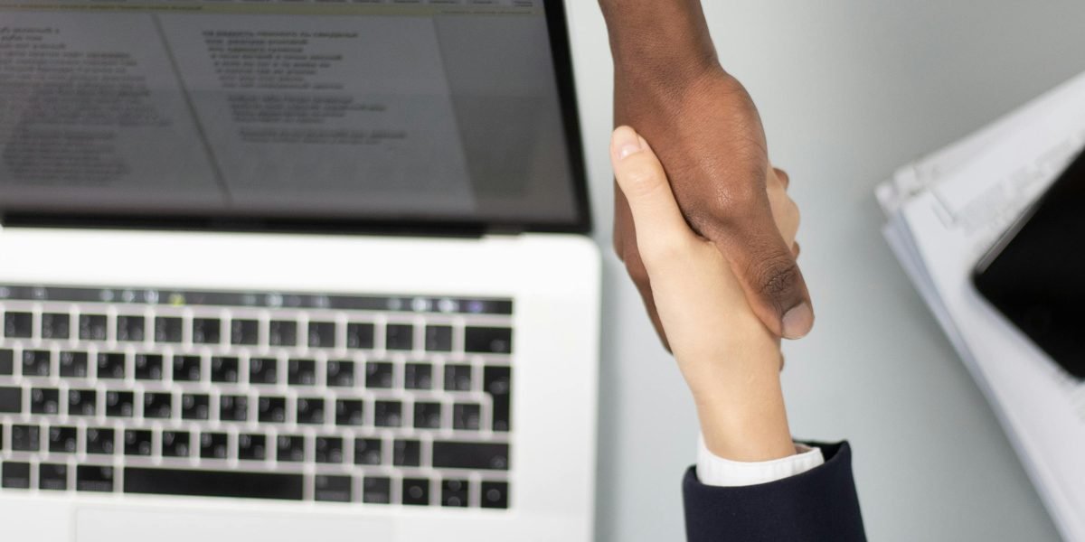 Two business people shaking hands, symbolizing a successful partnership or deal closure.