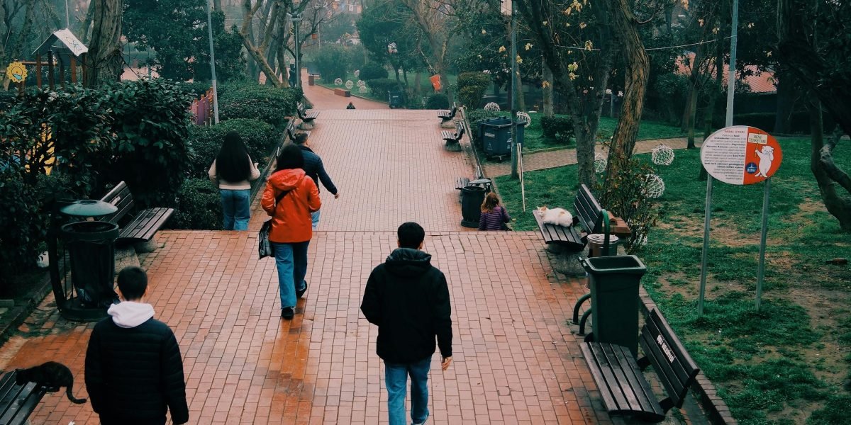 A family enjoying a leisurely walk in a peaceful, tree-lined residential neighborhood, reflecting Al Nahda's suburban feel.