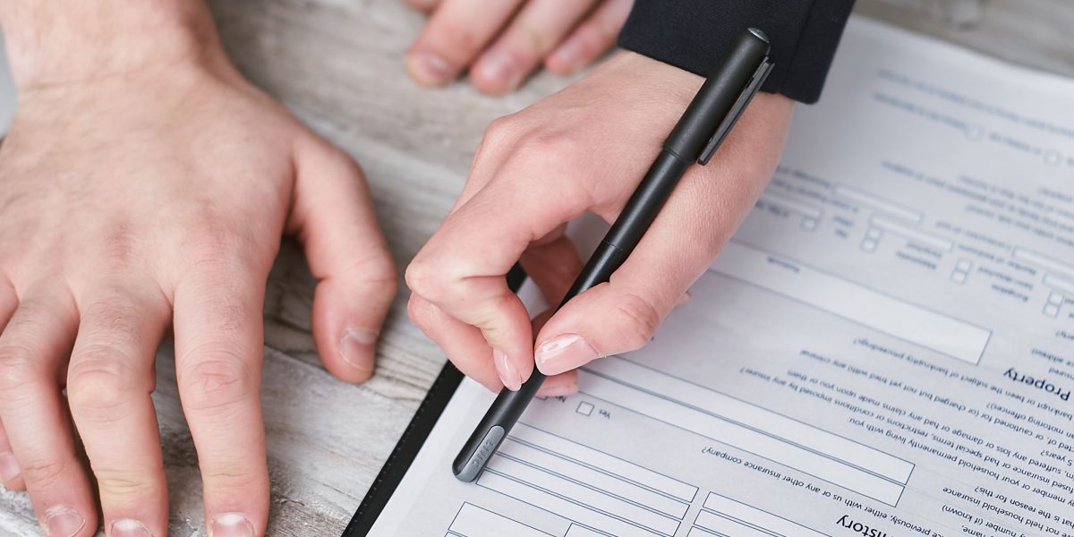 Individuals carefully reviewing legal contracts before signing, emphasizing the importance of understanding terms.