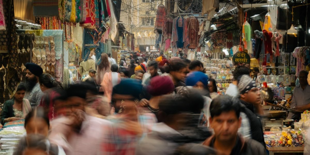 A bustling local market scene with people shopping, illustrating the convenience of nearby amenities in Al Rigga.