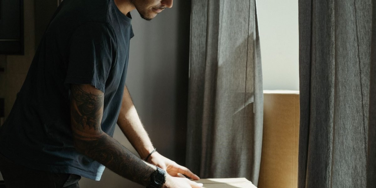 A person unpacking boxes in a new apartment, symbolizing the process of settling into a new home in Al Rigga.